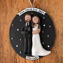 Load image into Gallery viewer, Decorative ornament with a couple illustration and 'New Year's Eve 2024' text on a wooden background