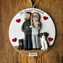 Load image into Gallery viewer, Personalized family ornament with two people, two dogs, and a baby on a wooden background.