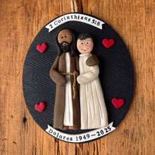 Load image into Gallery viewer, Decorative ornament with two people holding hands on a wooden surface