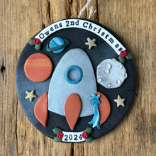 Load image into Gallery viewer, Decorative ornament with space-themed elements on a wooden surface
