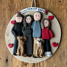 Load image into Gallery viewer, Personalized family ornament with four people and two dogs on a wooden surface
