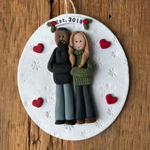 Load image into Gallery viewer, Decorative ornament with a couple holding hands and 'Est. 2018' text on a wooden surface.
