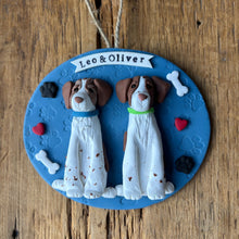 Load image into Gallery viewer, Decorative plaque with two dog figures and a blue background on a wooden surface

