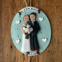 Load image into Gallery viewer, Decorative ornament with a couple holding hands on a wooden surface
