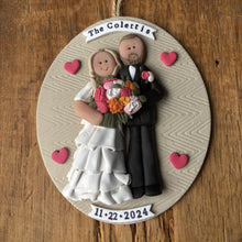 Load image into Gallery viewer, Personalized ornament with a bride and groom holding flowers on a wooden background
