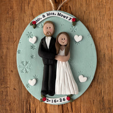 Load image into Gallery viewer, Wedding cake ornament
with figurines of a bride and groom on a round base with decorative elements.
