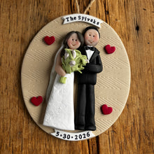 Load image into Gallery viewer, Personalized ornament with bride and groom figures on a wooden background
